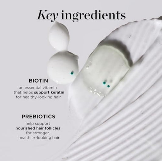 Close-up of white textured surface with biotin and prebiotics cream drops showing hair care ingredients